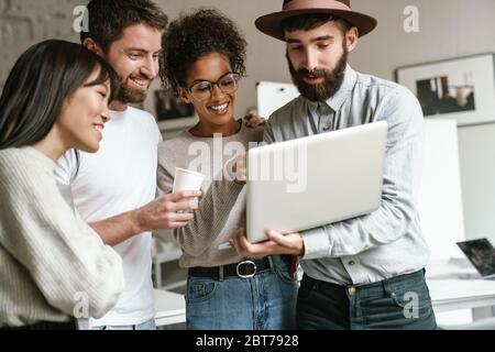Bild von multiethnischen jungen weiblichen und männlichen Geschäftsarbeitern, die im Büro zusammenstehen Stockfoto