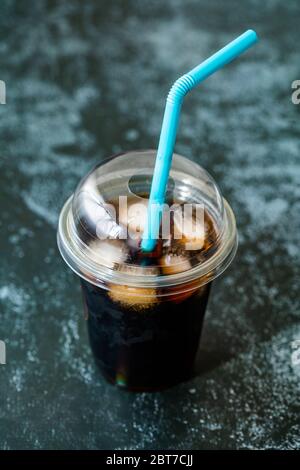 Zum Mitnehmen Kaltbrötchen Kaffee mit Eis aus Kunststoffglas und Stroh für den Sommer. Stockfoto
