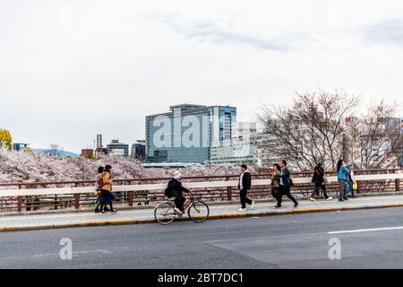 Osaka, Japan - 13. April 2019: Tenma-Brücke im Frühling mit Blick auf Kirschblüten Stadtbild der Innenstadt und Menschen überqueren Straße Stockfoto