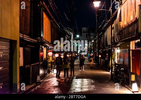 Kyoto, Japan - 16. April 2019: Gasse im Viertel Gion bei dunkler Abendnacht mit Menschen und beleuchteten roten Laternen-Papierlampen Stockfoto