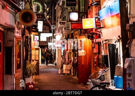 Tokio, Japan - 3. April 2019: Shinjuku im Stadtzentrum mit Golden Gai, einer engen Gassenstraße mit Izakaya-Restaurants in der Nacht und Schildern Stockfoto