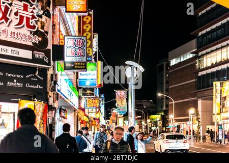 Tokio, Japan - 3. April 2019: Shinjuku Innenstadt mit Straße und Menschen, die abends an Izakaya Restaurants vorbei laufen und Schildern in der Nähe der Okubo Station auf der Straße Stockfoto