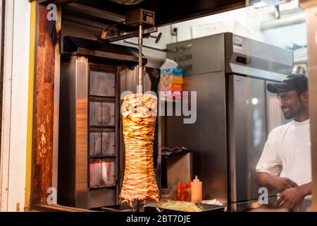 Tokio, Japan - 3. April 2019: Shinjuku im Stadtzentrum mit Kebab-Shop Restaurant-Theke Eingang Außenansicht Street Food mit Mann Ausländer Koch Stockfoto