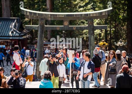 Nikko, Japan - 5. April 2019: Toshogu Tempel Schrein Eingang Stein torii Tor in Tochigi Präfektur mit vielen Menschen Touristen zu Fuß Stockfoto