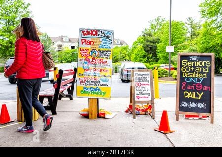 Reston, USA - 1. April 2020: Händler Joes Lebensmittelladen unterzeichnen für ältere behinderte Kunden spezielle Morgenstunden, Personen-Limit und Lebensmittel-Bagging-PAP Stockfoto