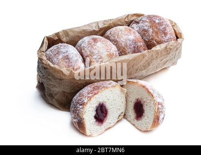 Frisch gebackene Donuts gefüllt mit Erdbeermarmelade in Papiertüte isoliert auf weiß Stockfoto