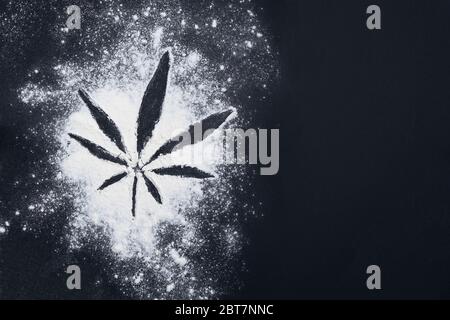 Cannabis Blatt Silhouette aus weißem Mehl auf schwarzem Hintergrund mit Platz für Text, Ansicht oben Stockfoto