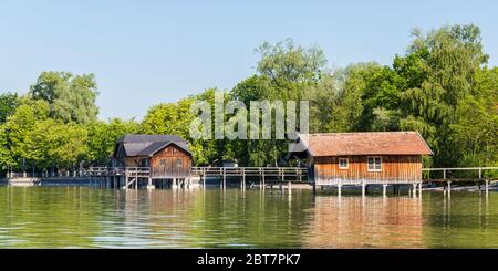 Hölzerne Bootshäuser am Ammersee (Ammersee) im Frühling. Beliebtes Ziel für Menschen aus München und Umgebung. Panoramafarma. Stockfoto