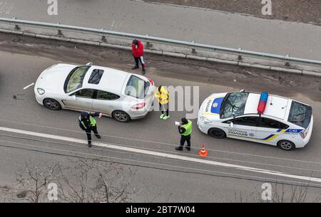 KIEW, UKRAINE - 02. FEBRUAR 2020: Eine Polizeipatrouille kommt bei einem Straßenfahrzeugunfall an, bei dem die nicht identifizierten Fahrer vor dem Fahrzeug stehen. Blick von Stockfoto