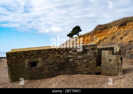 Kriegsbeengepfilder am Strand wegen der Erosion der Küste Stockfoto