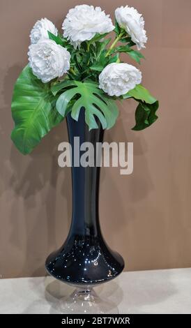 Bouquet von weißen Pfingstrosen Blumen in einer hohen schwarzen Vase Nahaufnahme Stockfoto