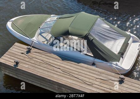 Luxusboot an einem sonnigen Tag, Blick von oben. Holzsteg am Fluss mit Seil und Ankerplatz. Stockfoto