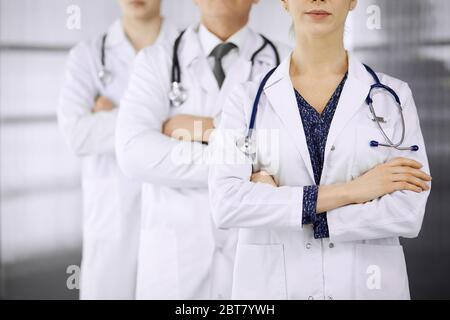 Ärzte stehen als Team mit gekreuzten Armen in der Klinik. Medizinische Hilfe, Versicherung und Medizin Konzept Stockfoto