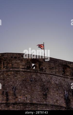 Union Jack Flagge fliegen während der Sperrung am Edinburgh Castle in der Dämmerung Stockfoto