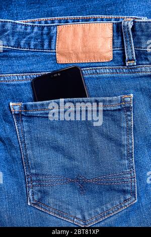 Nahaufnahme von Jeans Gesäßtasche aus klassischen blauen Denim-Hose mit Smartphone Stockfoto