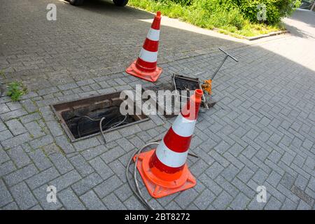 Reparaturarbeiten an der Fehlersuche oder kommunaler Servicearbeit. Öffnen Sie die Eisenklappe mit dem Kabel Stockfoto