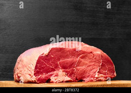 Rohes frisches Rindfleisch auf schwarzem Hintergrund. Gesundes Abendessen Empfang Konzept Stockfoto