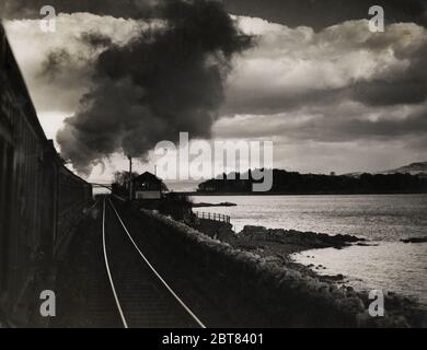 Vintage-Fotografie des frühen 20. Jahrhunderts - Dampfzug, der gegen den Himmel ragte, der die Ostküste Englands hinauf fuhr Stockfoto