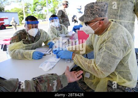US Air Force LT. Col. Francisco Nieves, ein Arzt der 156th Medical Group, verwendet einen schnellen COVID-19 Coronavirus-Test an einem Mitglied der Puerto Rico National Guard auf der Muñiz Air National Guard Base 22. Mai 2020 in Carolina, Puerto Rico. Stockfoto