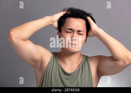junge Mann leidet unter Kopfschmerzen Stockfoto
