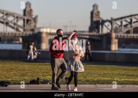 Sankt Petersburg, Russland. Mai 2020. Ein Paar, das Gesichtsmasken als Schutzmaßnahme trägt, tanzt am Neva-Damm. Russland hat mindestens 335882 Fälle und 3388 Todesfälle durch die COVID-19-Krankheit registriert Kredit: SOPA Images Limited / Alamy Live News Stockfoto