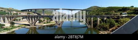 Brücken über den Douro Fluss östlich von Porto in der portugiesischen Weinregion, terrassenförmig angelegte Weinberge auf Hängen im Hintergrund, Peso da Regua, Portugal Stockfoto