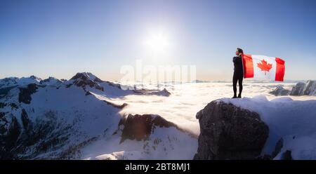 Epische abenteuerliche Extreme Composite von Mädchen mit einer kanadischen Flagge auf einem Berg. Landschaftshintergrund aus British Columbia, Kanada. Konzept: Stockfoto