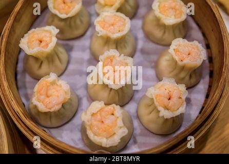 Frisch gedünstete traditionelle chinesische har gao Knödel mit Garnelen und Schweinefleisch in einem Dampfkorb in einem Restaurant in Singapur Stockfoto