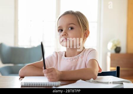 Gelangweilte kleine Mädchen Blick in der Ferne abgelenkt vom Studium Stockfoto