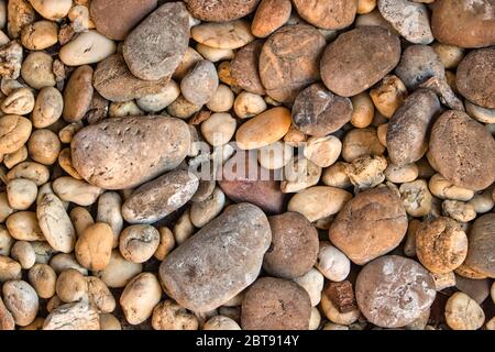Dieses einzigartige Foto zeigt viele kleine Steine von oben, die in verschiedenen Strukturen und Farben zu einem Gartenweg gehören Stockfoto