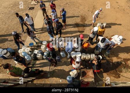 Caracas, Venezuela. Mai 2020. Die Leute stellen sich mit Kanistern und Schiffen an, um Wasser zu bekommen. In vielen Haushalten des Landes gibt es kein fließendes Wasser mehr. Die Wasserversorgung funktioniert teilweise nicht mehr. Die Coronavirus-Pandemie verschlimmert die Situation noch. Quelle: Pedro Rances Mattey/dpa/Alamy Live News Stockfoto