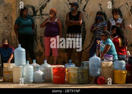 Caracas, Venezuela. Mai 2020. Im Bezirk Catia stehen die Menschen mit Kanistern und Schiffen an, um Wasser zu bekommen. In vielen Haushalten des Landes gibt es kein fließendes Wasser mehr. Die Wasserversorgung funktioniert teilweise nicht mehr. Die Coronavirus-Pandemie verschlimmert die Situation noch. Quelle: Pedro Rances Mattey/dpa/Alamy Live News Stockfoto