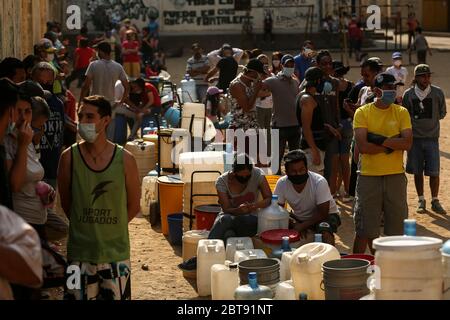 Caracas, Venezuela. Mai 2020. Die Leute stellen sich mit Kanistern und Schiffen an, um Wasser zu bekommen. In vielen Haushalten des Landes gibt es kein fließendes Wasser mehr. Die Wasserversorgung funktioniert teilweise nicht mehr. Die Coronavirus-Pandemie verschlimmert die Situation noch. Quelle: Pedro Rances Mattey/dpa/Alamy Live News Stockfoto