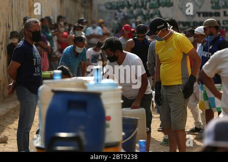 Caracas, Venezuela. Mai 2020. Die Leute stellen sich mit Kanistern und Schiffen an, um Wasser zu bekommen. In vielen Haushalten des Landes gibt es kein fließendes Wasser mehr. Die Wasserversorgung funktioniert teilweise nicht mehr. Die Coronavirus-Pandemie verschlimmert die Situation noch. Quelle: Pedro Rances Mattey/dpa/Alamy Live News Stockfoto