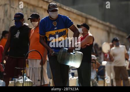 Caracas, Venezuela. Mai 2020. Die Leute stellen sich mit Kanistern und Schiffen an, um Wasser zu bekommen. In vielen Haushalten des Landes gibt es kein fließendes Wasser mehr. Die Wasserversorgung funktioniert teilweise nicht mehr. Die Coronavirus-Pandemie verschlimmert die Situation noch. Quelle: Pedro Rances Mattey/dpa/Alamy Live News Stockfoto