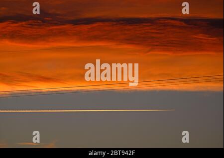 papenburg, deutschland - 2020-05-22: Ein Flugzeug, das in großer Höhe im Abendhimmel der norddeutschen ostfriesischen Provinz unterwegs ist und Kondensstreifen verlässt Stockfoto