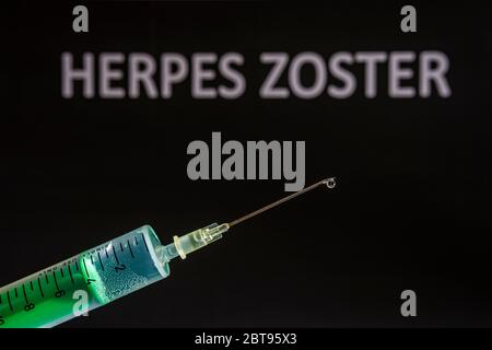 Diese Abbildung zeigt eine Einweg-Spritze mit hypodermischer Nadel, HERPES ZOSTER auf einem schwarzen Brett dahinter geschrieben Stockfoto