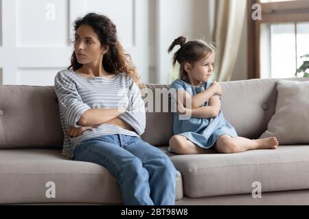 Verärgerte Mutter und kleine Tochter ignorieren einander nach Streit Stockfoto