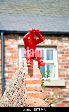 Roter Mann mit Fernglas an der Gartenmauer, Hurworth auf Tees, Borough of Darlington, England Stockfoto