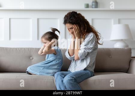 Hartnäckige verdorbene kleine Mädchen Ohren bedeckt, ignorieren hoffnungslos verärgert Mutter Stockfoto