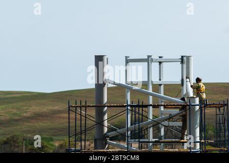 Arbeiter arbeiten auf einer Baustelle, während auf Gerüsten.Metallbau. Stockfoto