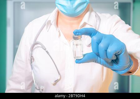 Fläschchen mit Impfstoff in der Hand eines Arztes oder Wissenschaftlers im Labor Stockfoto