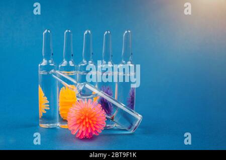 Abstraktes Modell des Coronavirus und Ampulle mit Medizin auf blauem Hintergrund. Coronavirus stoppen. Stockfoto