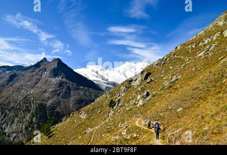 SaaS Fee, Schweiz - 26. September 2019: Wanderweg in Saas Fee. Kleine Gruppe von Wanderern auf dem Weg. Stockfoto