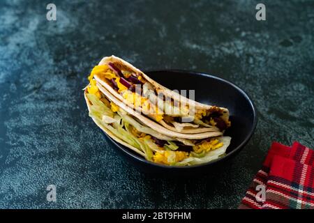 Taco Cig Kofte im türkischen mexikanischen Stil mit Kidney Beans, roten Zwiebeln, geriebenem Cheddar-Käse und Granatapfelsauce. Traditionelles Fast Food. Stockfoto