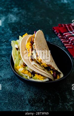 Taco Cig Kofte im türkischen mexikanischen Stil mit Kidney Beans, roten Zwiebeln, geriebenem Cheddar-Käse und Granatapfelsauce. Traditionelles Fast Food. Stockfoto