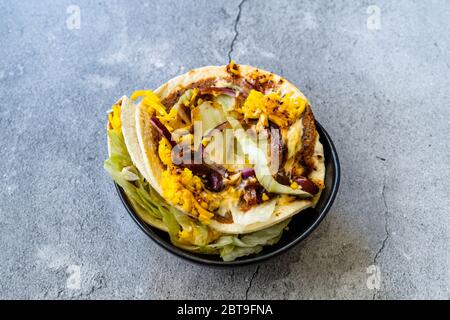 Taco Cig Kofte im türkischen mexikanischen Stil mit Kidney Beans, roten Zwiebeln, geriebenem Cheddar-Käse und Granatapfelsauce. Traditionelles Fast Food. Stockfoto