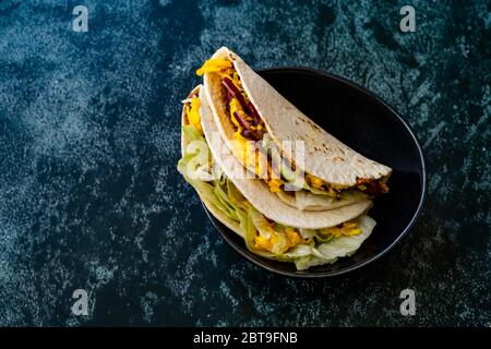 Taco Cig Kofte im türkischen mexikanischen Stil mit Kidney Beans, roten Zwiebeln, geriebenem Cheddar-Käse und Granatapfelsauce. Traditionelles Fast Food. Stockfoto