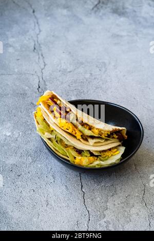 Taco Cig Kofte im türkischen mexikanischen Stil mit Kidney Beans, roten Zwiebeln, geriebenem Cheddar-Käse und Granatapfelsauce. Traditionelles Fast Food. Stockfoto