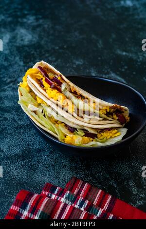 Taco Cig Kofte im türkischen mexikanischen Stil mit Kidney Beans, roten Zwiebeln, geriebenem Cheddar-Käse und Granatapfelsauce. Traditionelles Fast Food. Stockfoto